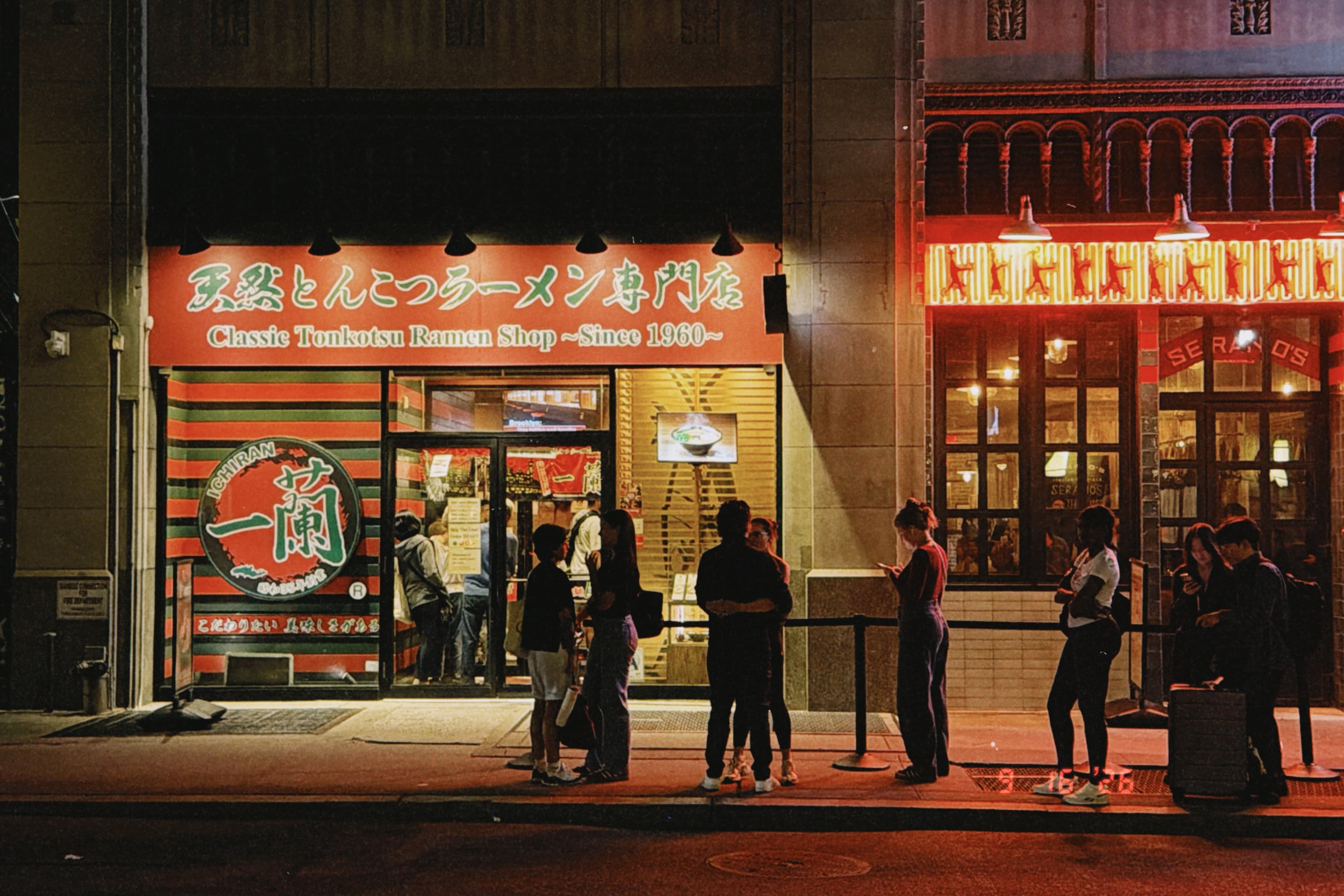 Ichiran ramen shop at night, queue along the sidewalk under neon